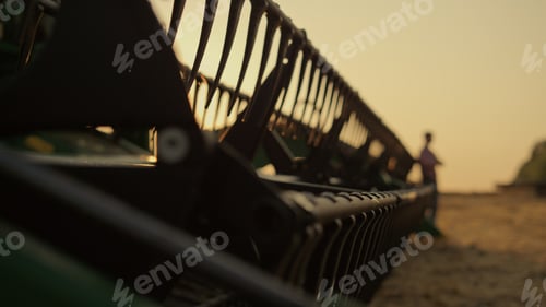 Preview: Agronomist silhouette rest wheat farmland lean harvester machine golden sunset.
