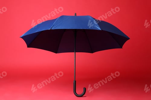 Preview: Stylish open blue umbrella on red background