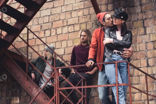 Preview: group of young stylish people standing on stairs of old industrial building