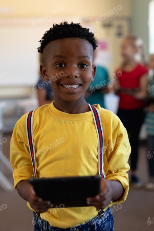 Preview: Schoolboy using a tablet computer in an elementary school classroom