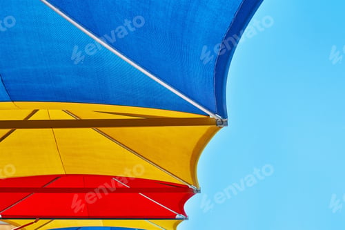 Preview: Colored beach umbrellas against blue sky in the summer day