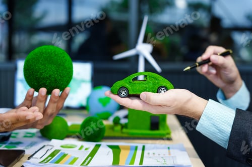 Preview: A meeting at an office desk focuses on teamwork with a house model and discussions on electric cars