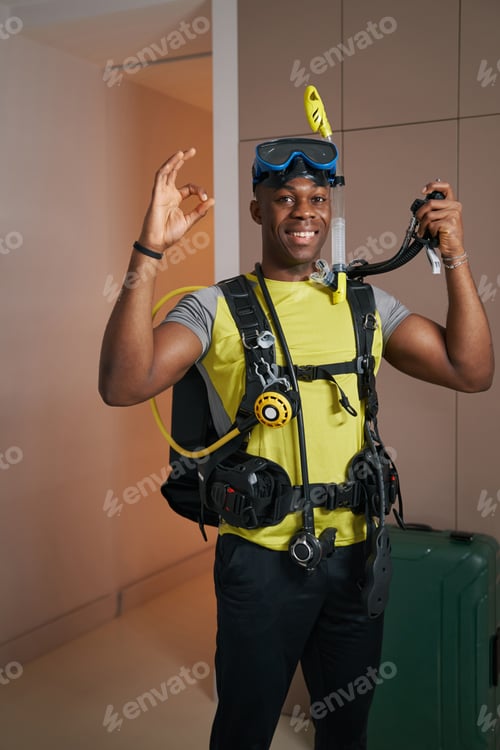 Preview: Smiling man in scuba suit showing ring gesture