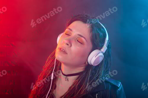 Visualização: Jovem mulher com dreadlocks curte a música em seus fones de ouvido