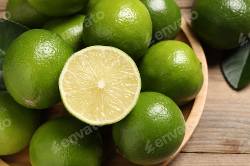 Preview: Whole and cut fresh limes on table, closeup