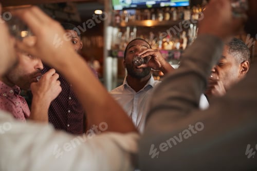 Preview: Group Of Male Friends On Night Out Drinking Shots In Bar Together