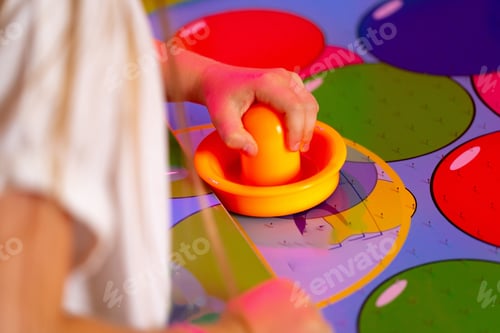 Preview: Young Child Playing Twister Game With Colorful Spinner on Bright Mat