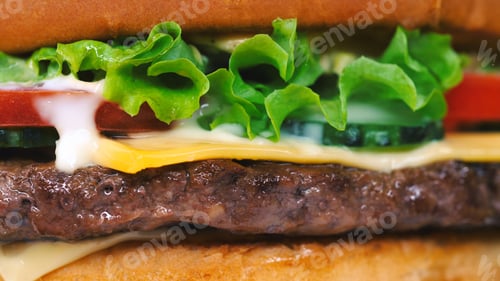 Preview: Macro detailed view of juicy beef burger layers. Cutlet, onion, vegetables, melted cheese, lettuce