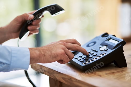 Preview: Dial those digits. Cropped shot of a man dialing a number on a telephone at work.
