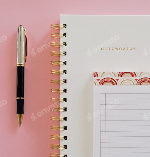 Preview: Notebook with gold binding lined notepad and pen on a pink background