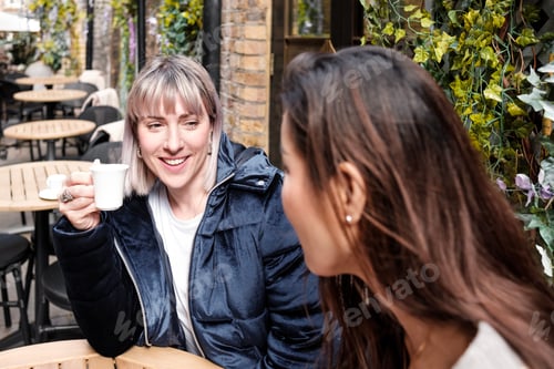 Preview: Two mature women friends having a coffee in a terrace.