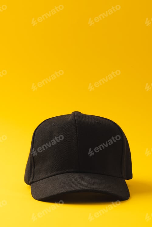 Preview: Black baseball cap and copy space on yellow background