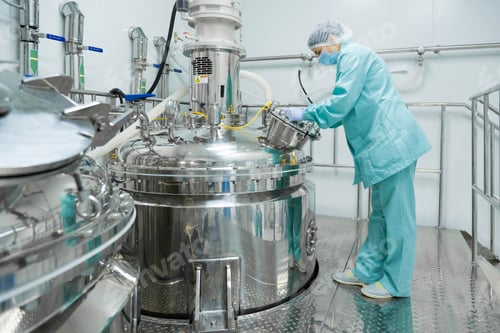 Preview: Pharmaceutical factory woman worker in protective clothing operating production line in sterile