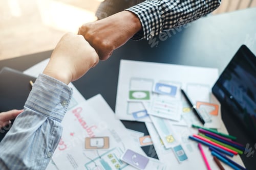 Preview: Close-up. Two application designer fist bump showing cooperation and Success at work.