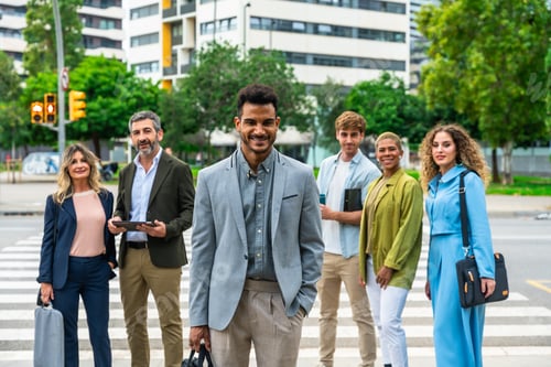 Preview: Diverse business team smiling at camera in city street