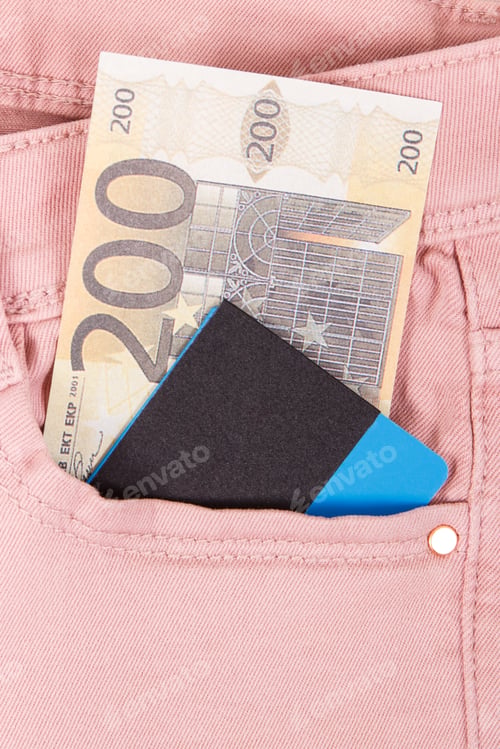 Preview: Money and credit card in pocket of pink trousers. Finance and banking