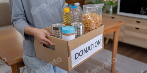 Preview: Person Holding a Donation Box Filled with Food Items and Essential for Charity and Community