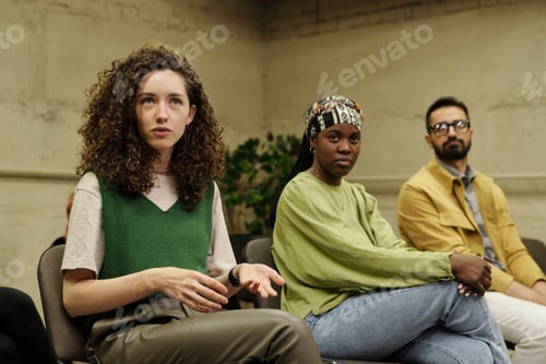 Preview: Young businesswoman in casualwear asking qiestion to speaker after report