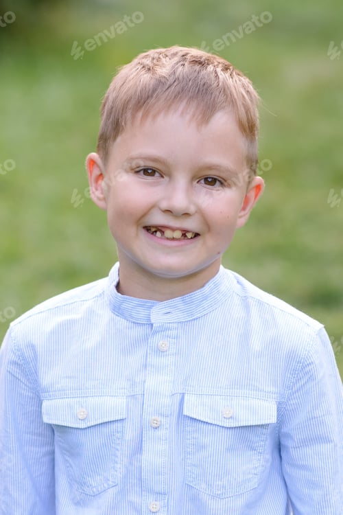 Preview: Portrait of a child boy outdoors on a warm sunny summer day. The boy is smiling.
