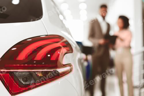 Visualização: Mulher irreconhecível assinando contrato parada perto de carro no escritório da concessionária