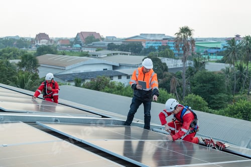 Preview: Engineers and technicians wearing full harnesses and helmets Solar panels, survey the job site