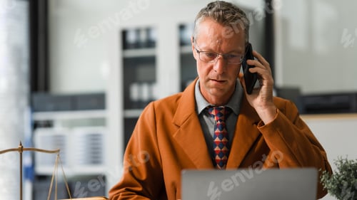 Preview: An elderly Caucasian male lawyer works at his desk in law firm,offering legal advice business law