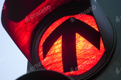 Preview: Closeup of a red traffic light with an arrow direction sign