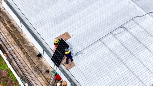 Preview: Solar panels installed on a corrugated metal roof, with technicians working