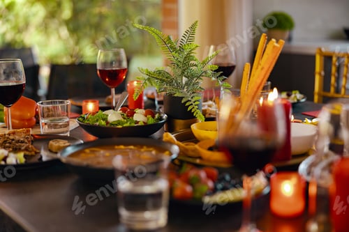 Preview: Cozy holiday table with different delicious food, beverages and candles ready for friends home