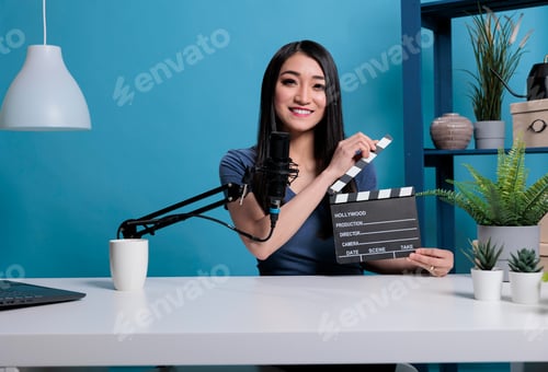 Preview: Movie director clapping film slate in front of camera recording videoblog