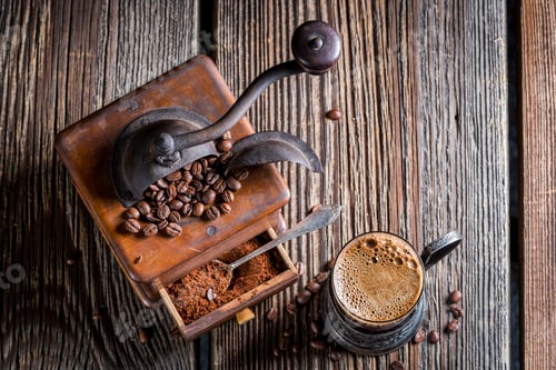 Preview: Fresh ground coffee and old grinder on old wooden table
