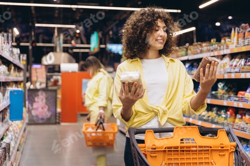 Preview: Woman choosing between white and brown rice in supermarket