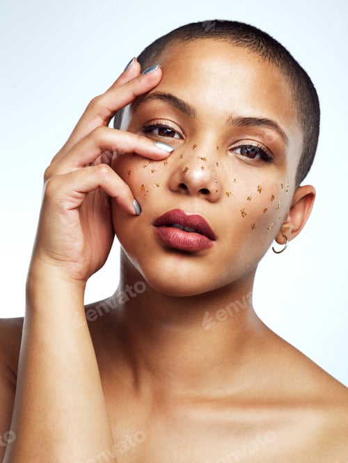 Preview: Studio shot of a beautiful young woman posing with glitter freckles on her face