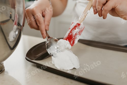 Preview: А Close Photo Of The Hands Of A Young Woman Who Is Putting The Freshly Whipped Meringue On A Tray