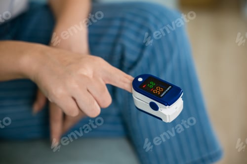 Preview: Young woman finger inserted into the pressure oximeter to assess health