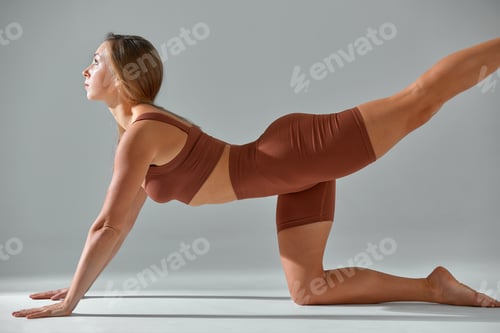 Preview: Yoga, pilates, sport and fitness concept: fit woman in biege leggings and top working out, warming