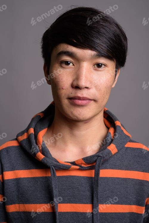 Preview: Young Asian man wearing striped hoodie against gray background