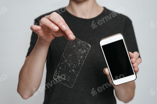 Preview: Worker of service center showing smartphone and broken screen protection.