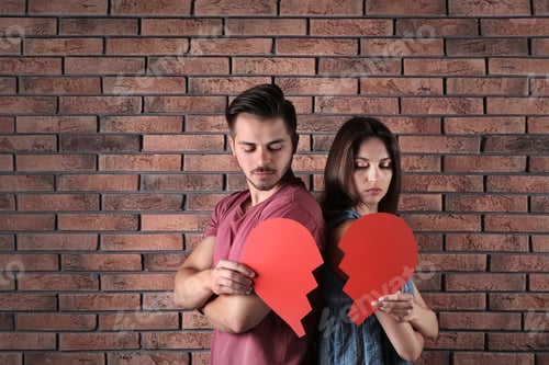 Preview: Young couple with torn paper heart near brick wall. Relationship problems