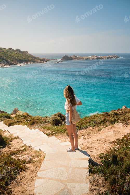 Preview: Tourist admiring breathtaking turquoise waters of sardinia, italy