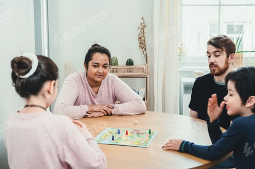Preview: Family spending time at home playing the board game