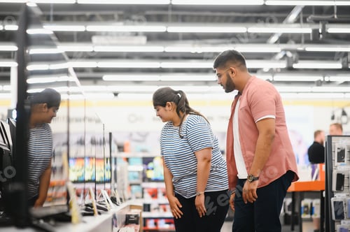 Preview: Beautiful couple buying consumer tech products in modern home appliances store