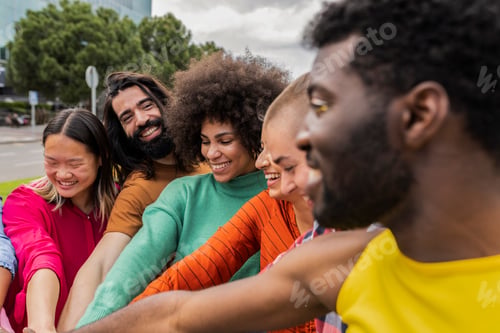 Preview: united group of friends joined in a circle by their hands while looking at each other and smiling
