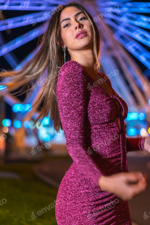 Preview: Portrait of a young brunette woman smiling on an illuminated Ferris wheel