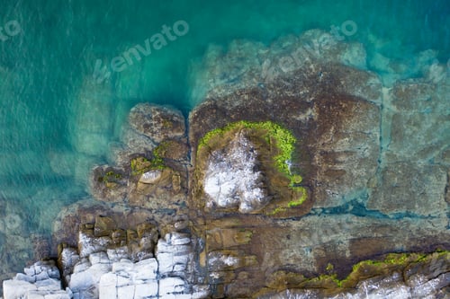 Preview: Aerial drone view of a remote rocky island in open sea.