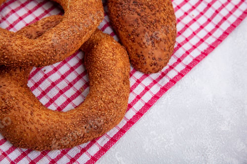 Preview: top view of soft and delicious sesame patties with turkish bagels isolated on a red checked cloth on