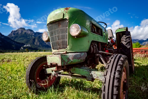 Preview: Vintage Green Tractor in Field with Mountain Backdrop