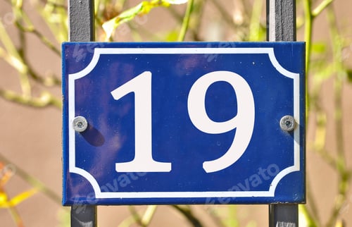 Preview: Closeup shot of a blue sign with the number 19 on the blurry background