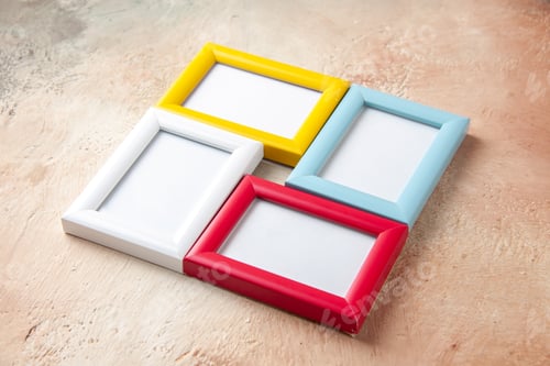 Preview: Side view of colorful picture frames hanging on nude color wall with free space