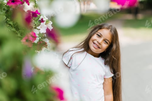 Preview: Beautiful Little Girl with Long Hair in Bright Colors in Summer in the Park